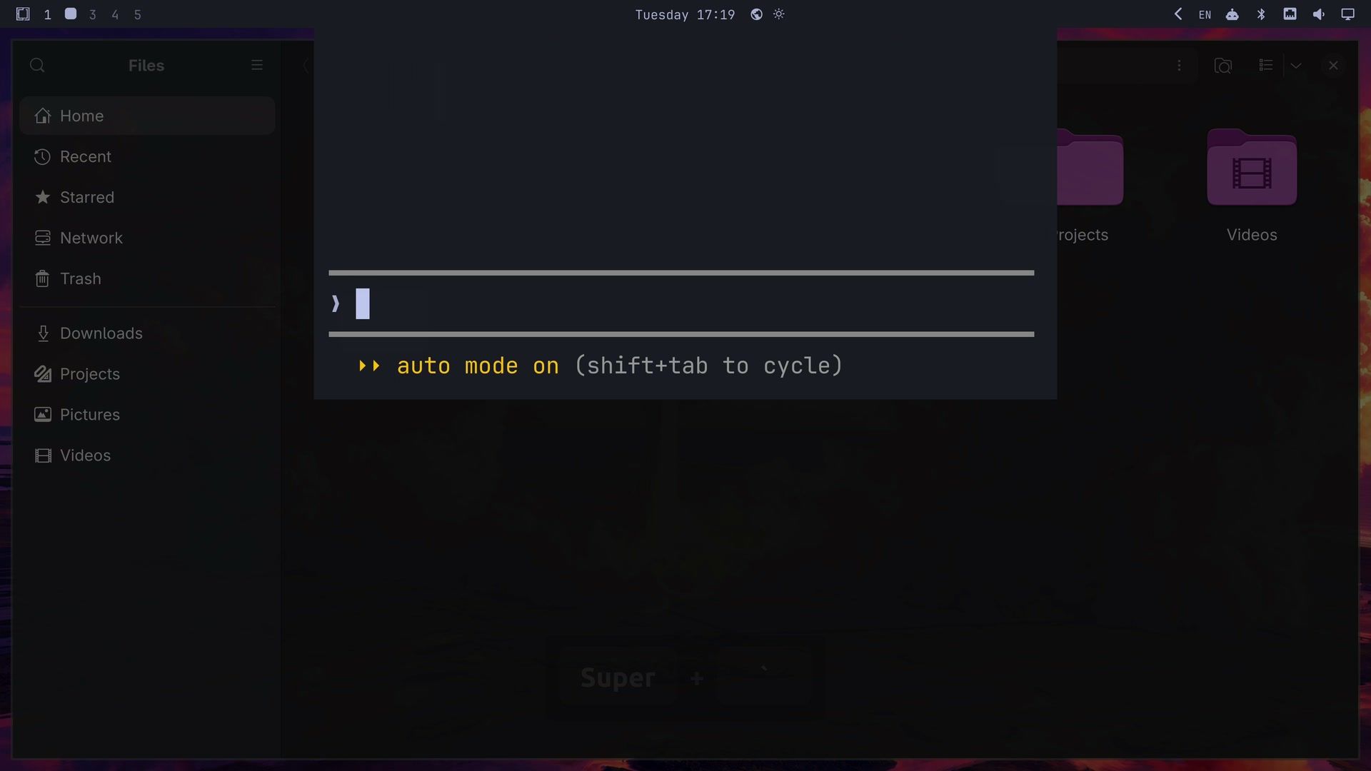 The Omarchy drop-down console, a terminal panel under the top bar running Claude Code with an empty prompt, over a dimmed Files window